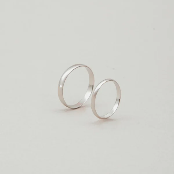 Argollas de matrimonio de oro blanco 18K estilo inglés, par completo de pie sobre fondo claro